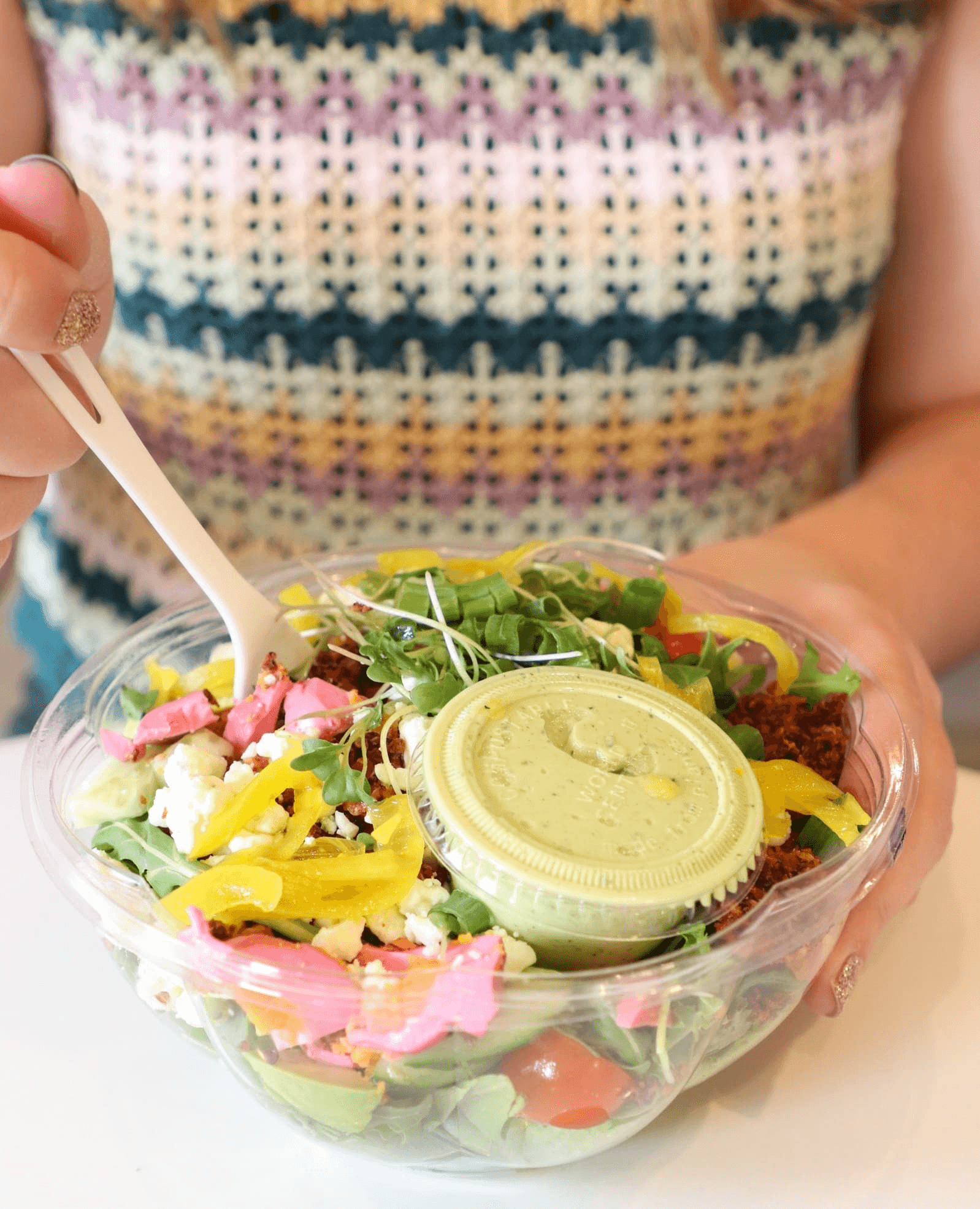 Woman holding salad in sustainable container