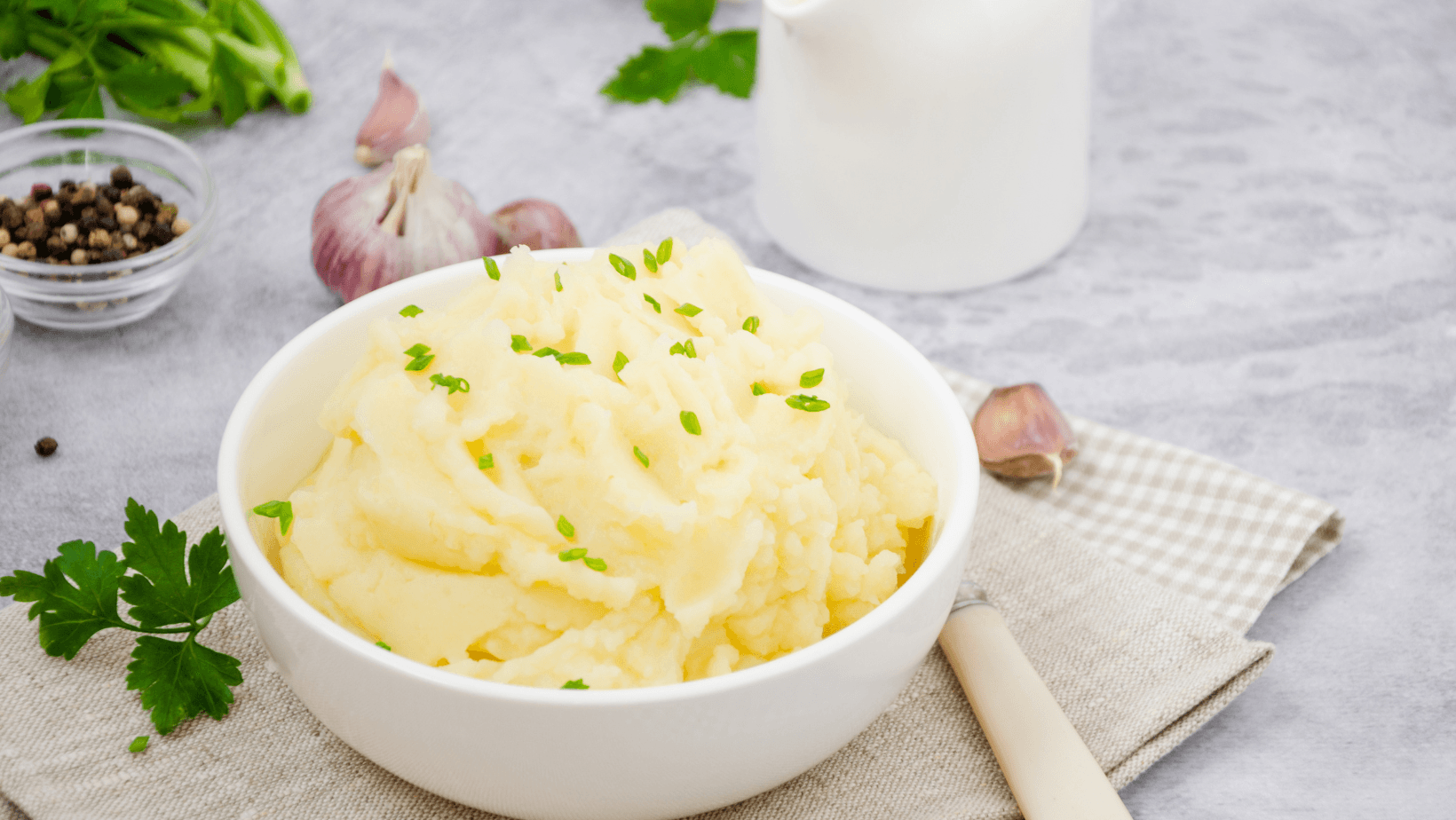 Vegan Mashed potatoes with butter, milk, garlic and green onions in a bowl on a gray background. A traditional dish of Ukrainian, Russian cuisine