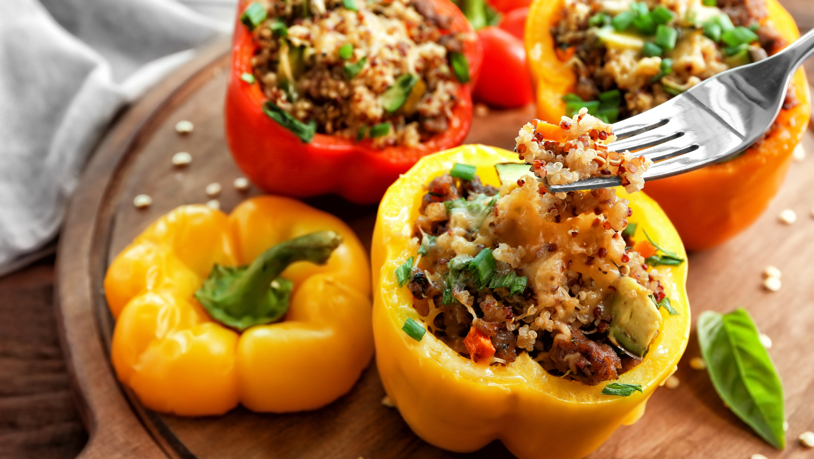 Eating of quinoa stuffed pepper on wooden board