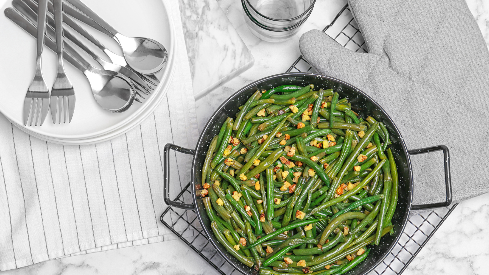 Yummy green beans with almonds in serving pan on table