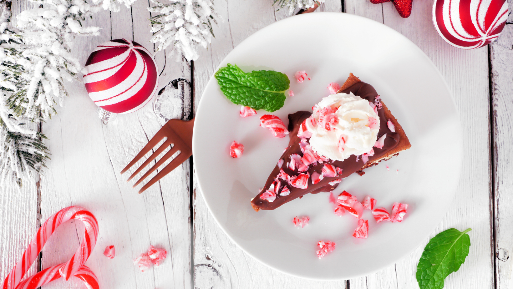 Christmas candy cane chocolate cheesecake. Top view table scene against a white wood background.