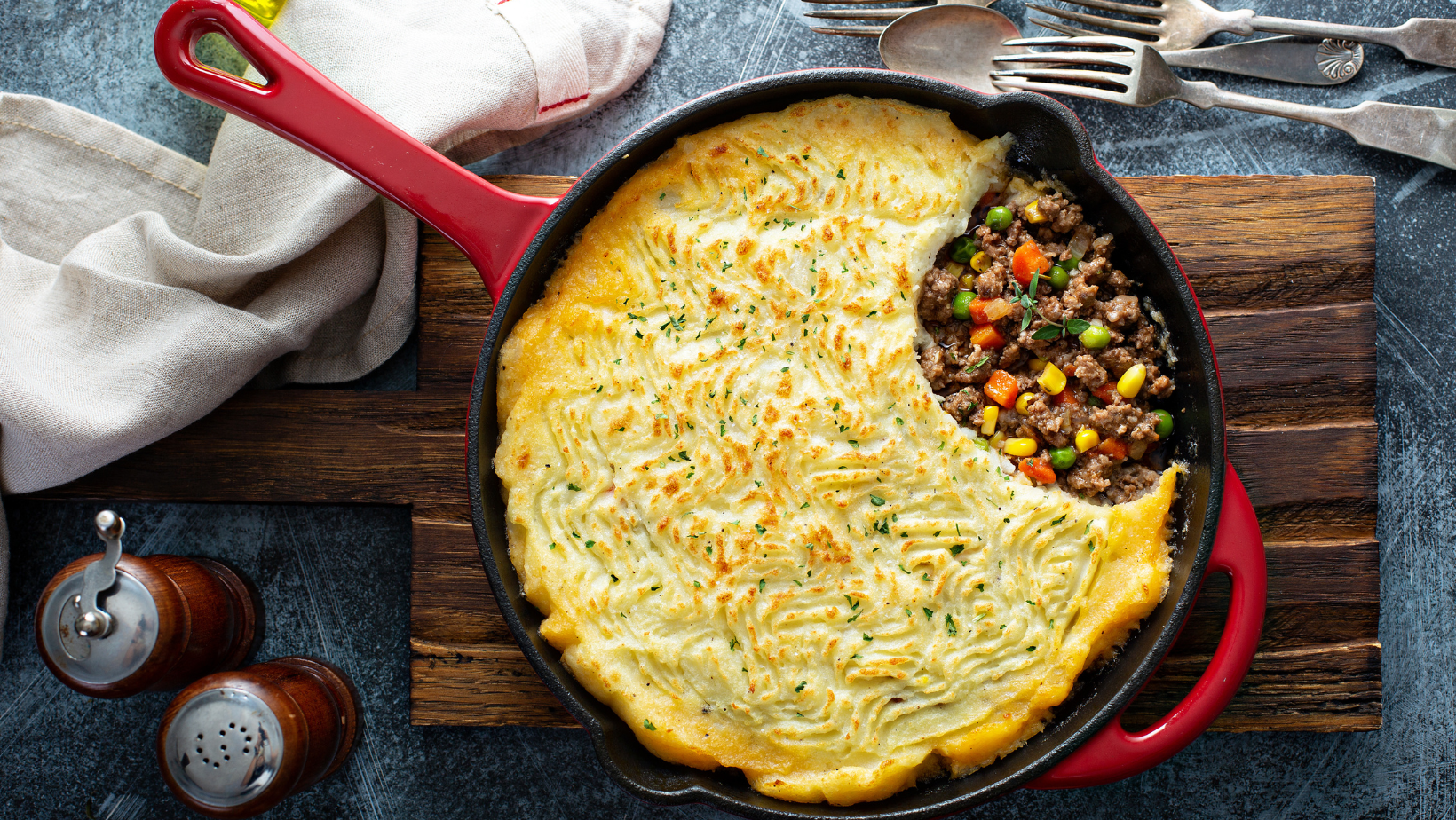 Shepherds pie with ground meat, vegetables and potatoes in a cast iron pan top view